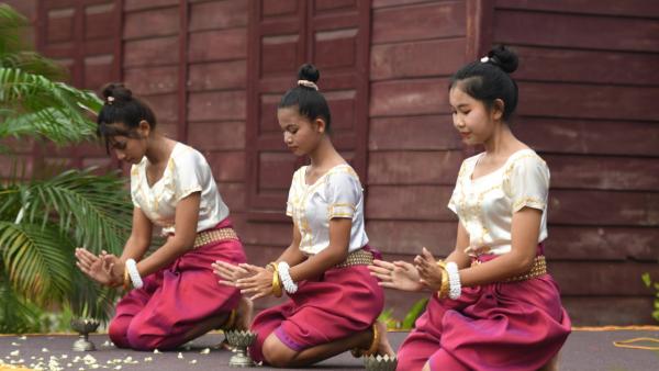Trois jeunes filles dansent une danse traditionnelle khmère