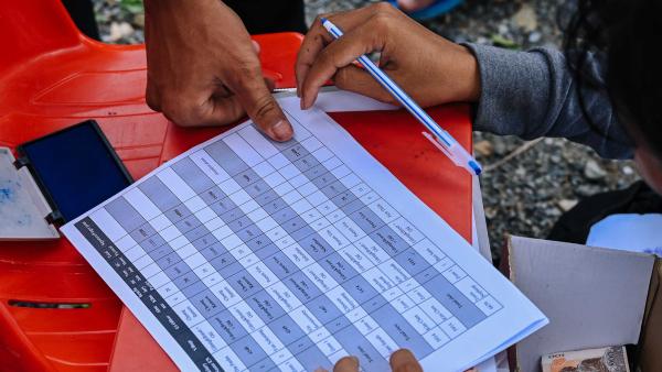 Un bénéficiaire signe avec son emprunte de doigt lors d'une distribution de riz à Oudong