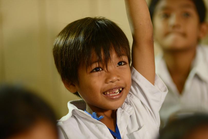 Un petit garçon en classe à PSE lève le doigt