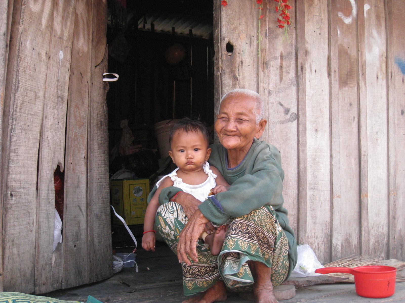 Une grand-mère tient sa petite fille dans ses bras dans une communauté pauvre de la périphérie de Phnom Penh